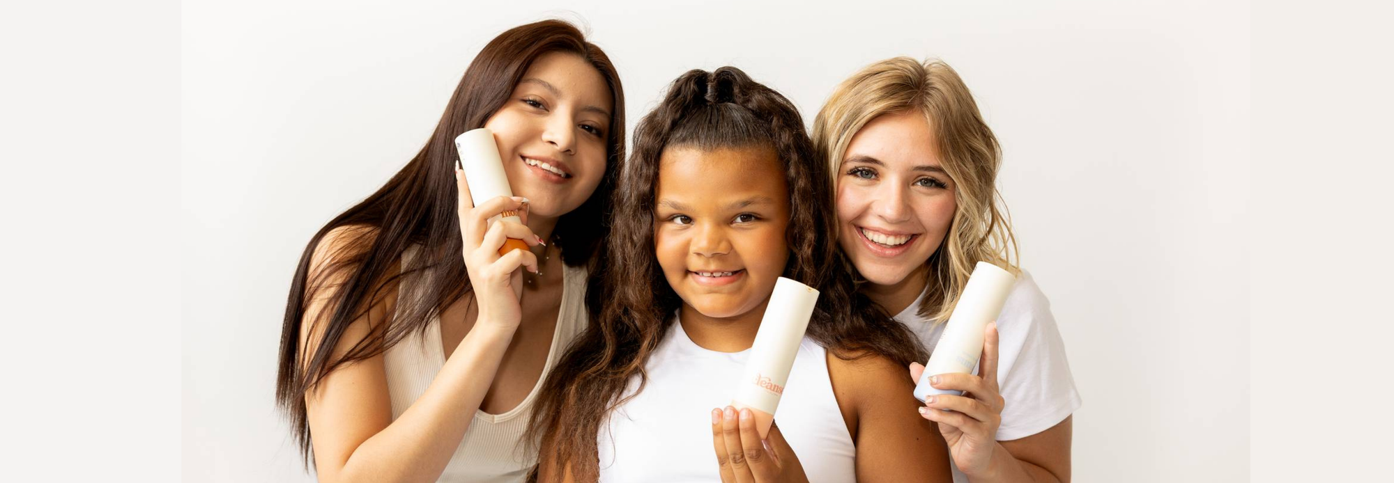 A hand pours sunscreen from a Girlyish bottle labeled “Broad Spectrum SPF 30.” The product is mid-stream, and the soft blue background gives the image a clean, clinical, yet calming tone.
