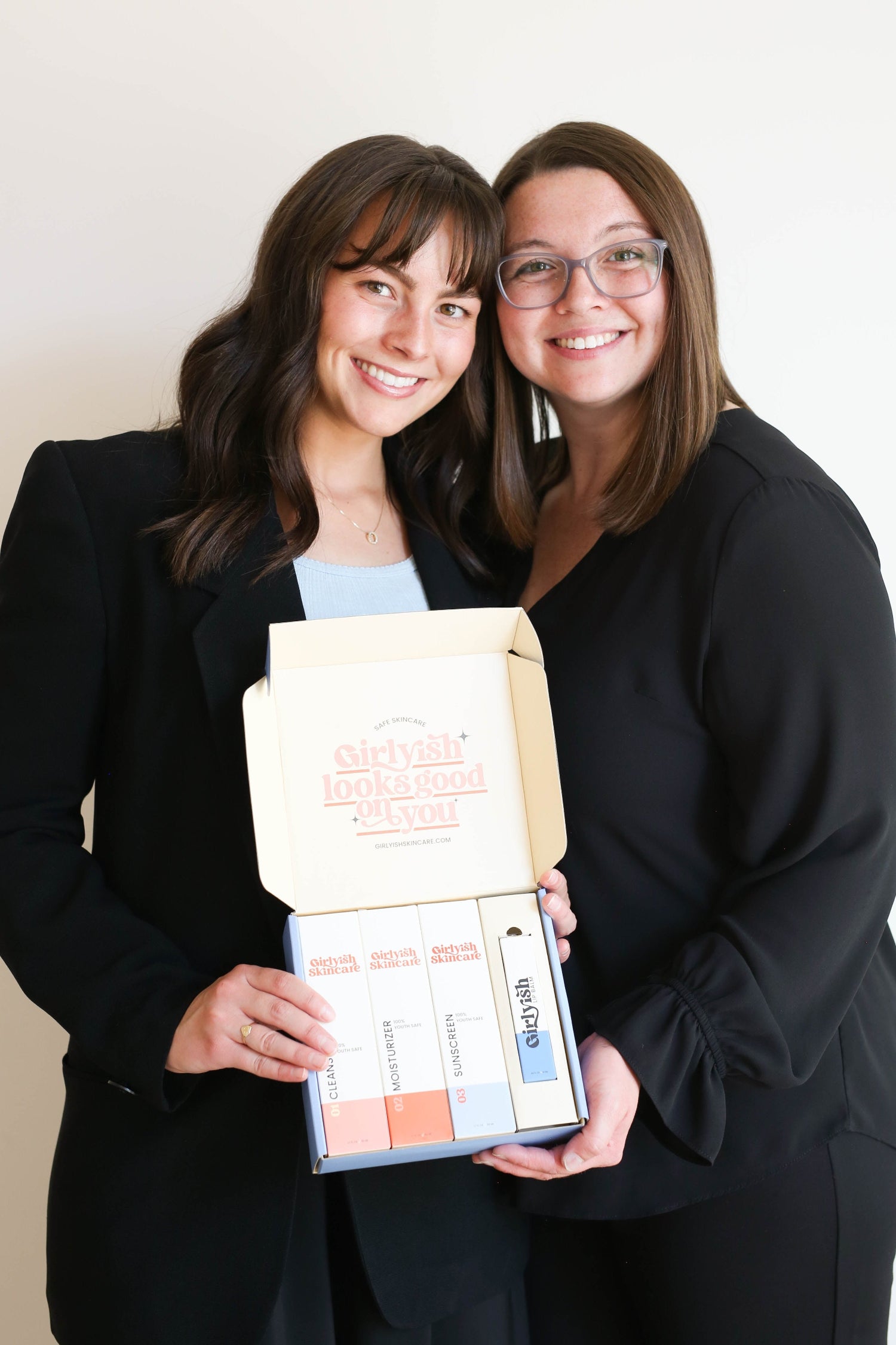 Macy Schmitt and Madison Heiner: co-founders of Girlyish Skincare holding the Girlyish 3-step routine for tween and teen girls.