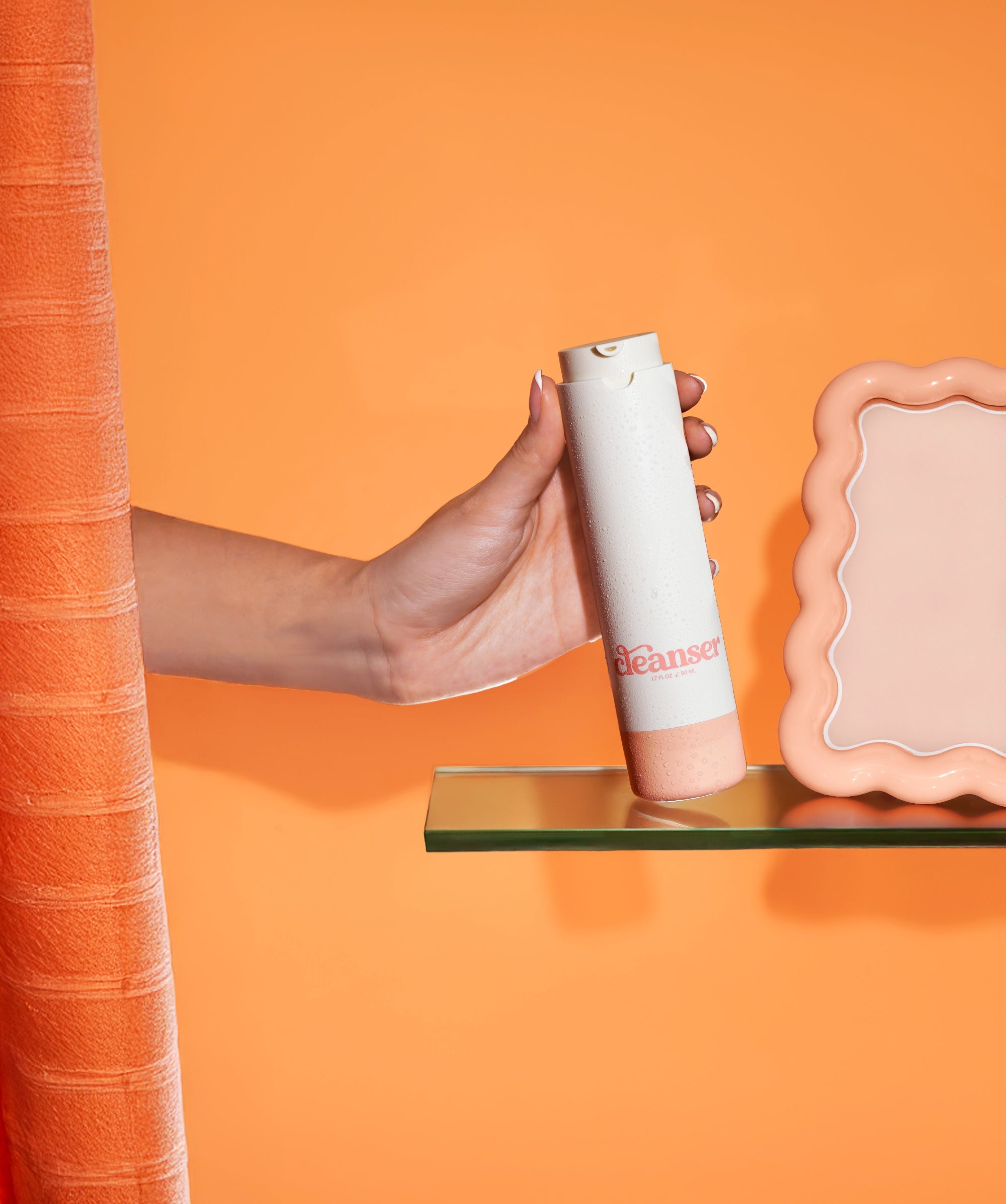 A girl reaching for the Girlyish facial Cleanser from behind a shower curtain