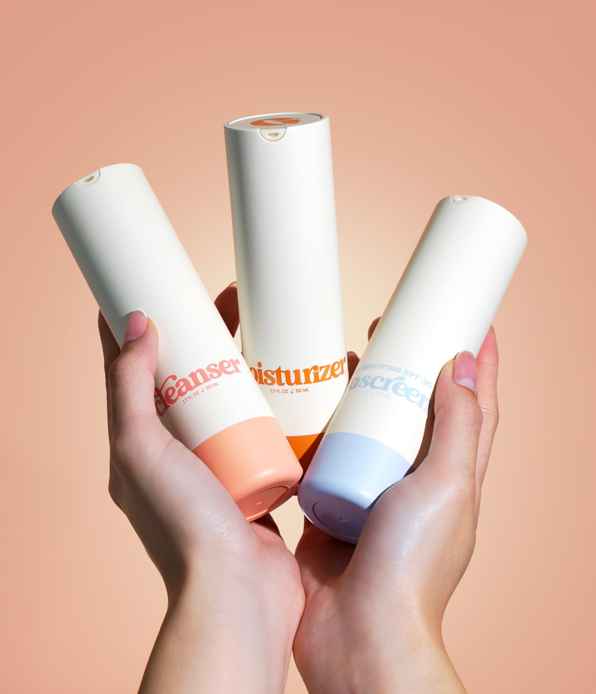 A photo of a woman's hand holding Girlyish cleanser, moisturizer, and sunscreen